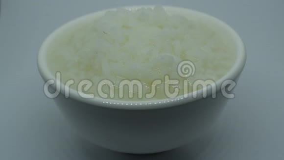 白色背景的杯中煮米饭视频的预览图