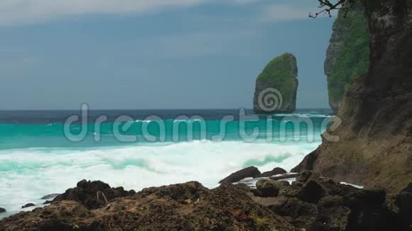 登伯岭海岸线的岩石在努沙佩尼达伊斯兰向海岸移动的海浪印度尼西亚视频的预览图