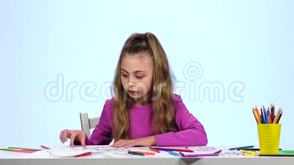 小女孩找到合适的铅笔并画画白色背景慢动作视频的预览图