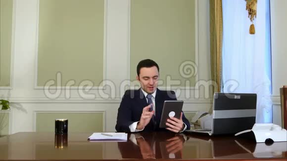 商人在平板电脑上聊天在办公室做文书工作视频的预览图