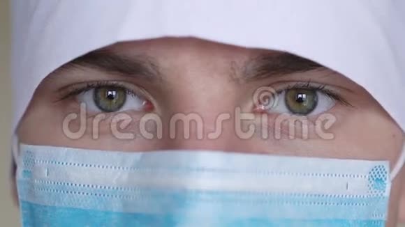 一名男性外科医生正戴着外科口罩看着摄像机脸上的表情视频的预览图