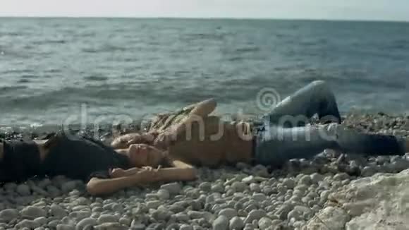 年轻夫妇躺在海滩上视频的预览图