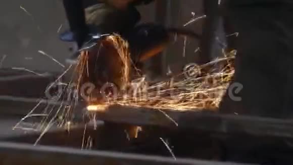 一个人用磨床工作在工厂切割钢结构美丽的火花飞出视频的预览图