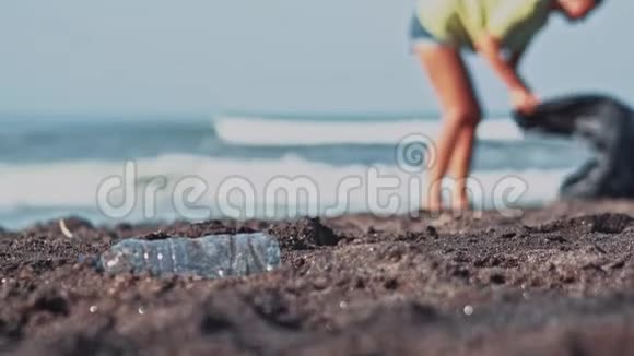 群志愿者清理沙滩志愿者举起一个塑料瓶扔进袋子里志愿服务和视频的预览图