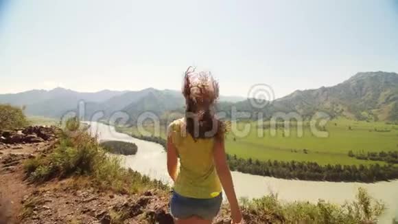 美丽的女人站在山顶伸出双手视频的预览图