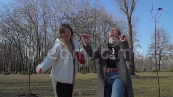 有趣的女孩随着音乐的节拍跳舞在公园里唱歌视频的预览图