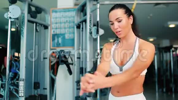 可爱的黑发女人在健身房锻炼双手视频的预览图