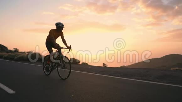 骑自行车的运动员从山上的岩石上走过蛇形地看着岛上美丽的景色这就是视频的预览图