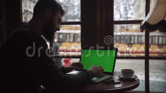 在咖啡厅使用带有绿色屏幕的笔记本电脑视频的预览图