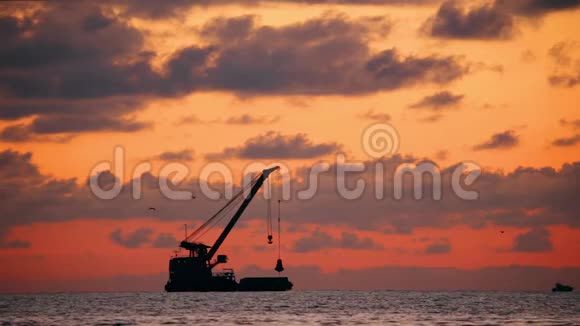 日落时海平线上的日落在海景的地平线上渔船的黑暗剪影自然日出天空视频的预览图