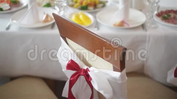 在婚宴或招待会上白色的椅子和红色的蝴蝶结贴在室内结婚装饰品大日子视频的预览图