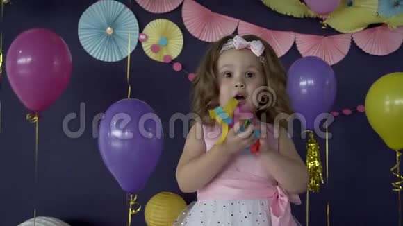 可爱的小女孩在她的生日聚会上吹纸屑视频的预览图