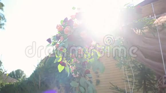 夏季花园婚礼拱门的漂亮装饰阳光透过花朵照耀视频的预览图