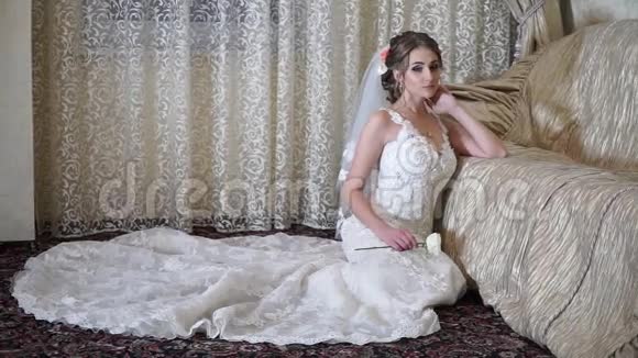 怀着悲伤的双眼体贴的新娘坐在沙发旁视频的预览图