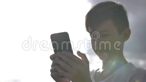 男孩在户外使用手机移动摄像头视频的预览图