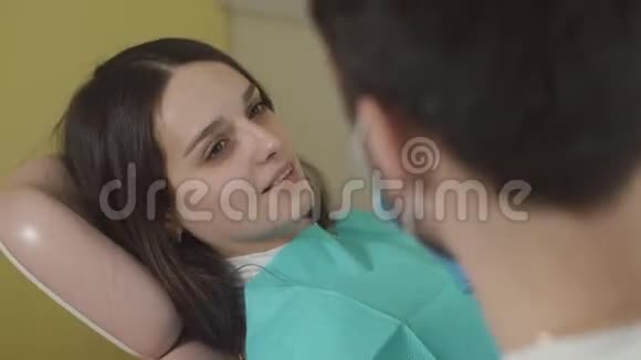 口腔和牙齿的检查坐在牙科椅上的漂亮年轻女人视频的预览图