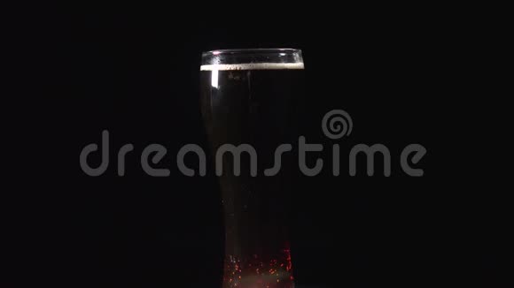 一品脱黑啤酒在黑色背景下旋转结实的玻璃在旋转视频的预览图