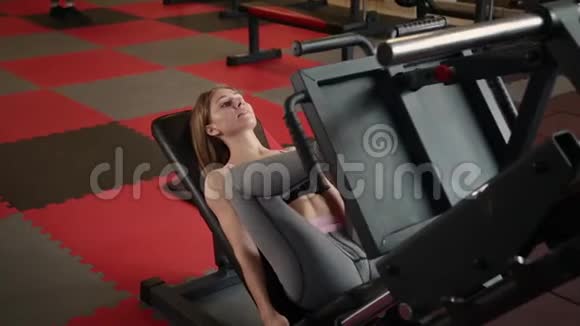 那个女孩在健身房做压腿机视频的预览图