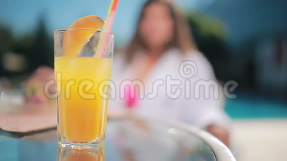 女人在模糊的背景上喝橙汁视频的预览图