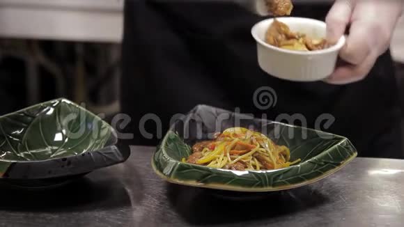 男人把一盘意大利面放在盘子里站在厨房的桌子上视频的预览图