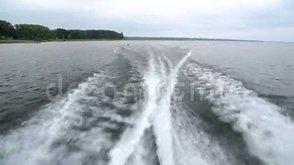 在湖边游弋的快艇后面的海浪视频的预览图
