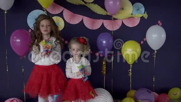 两个漂亮的女婴姐妹扔着鲜艳的纸屑庆祝生日视频的预览图