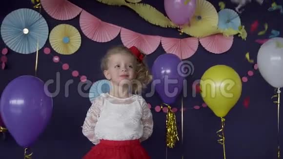 可爱的女婴抓着鲜艳的纸屑庆祝她的生日聚会视频的预览图