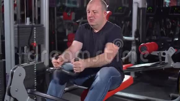 锻炼背部肌肉那些在健身房用赛艇机成功的人在健身机上的男人视频的预览图