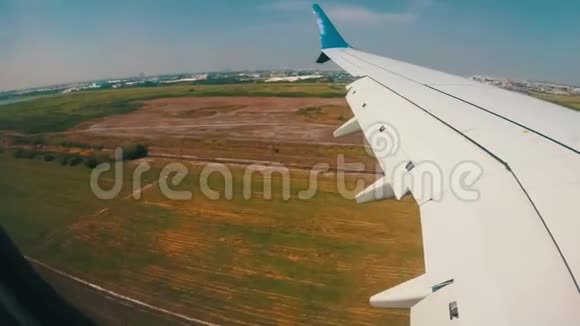 从窗口可以看到一架飞机的机翼该飞机低空降落在机场视频的预览图