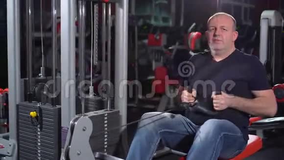 锻炼背部肌肉那些在健身房用赛艇机成功的人在健身机上的男人视频的预览图