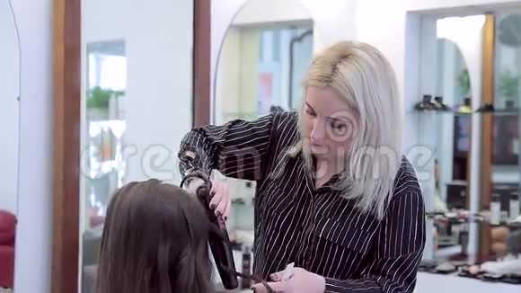 理发师为长发女孩制作自然卷发视频的预览图