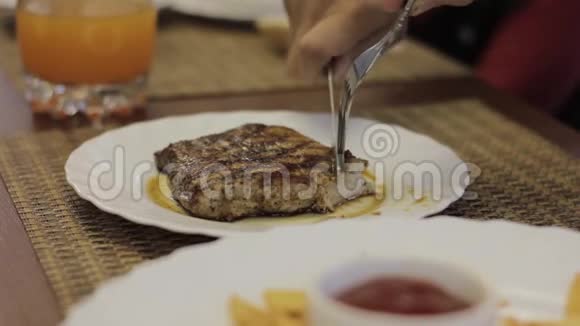 在白盘上切烤牛肉少年在咖啡馆里吃肉视频的预览图