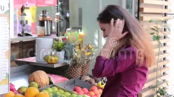 快乐的女人选择户外水果喝新鲜果汁视频的预览图