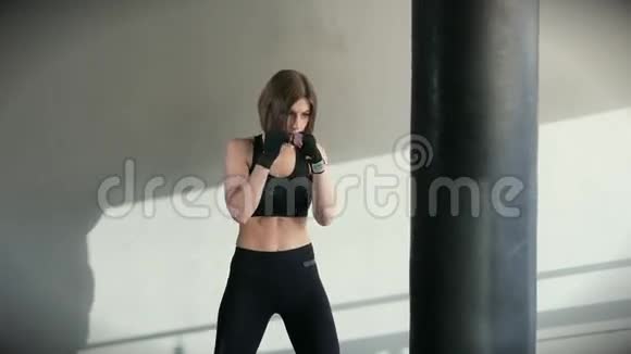 这位女运动员自信地用手在体育馆的拳击袋里击球视频的预览图