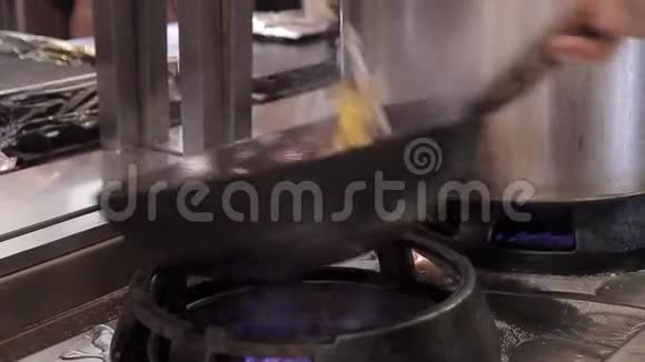 厨师在餐厅厨房的炉子与炒锅混合蔬菜虾海鲜视频的预览图