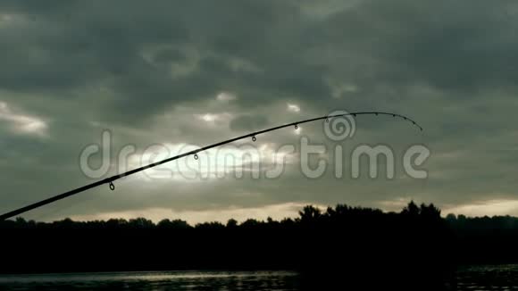 钓竿在河底傍晚多云的天空晚上钓鱼视频的预览图