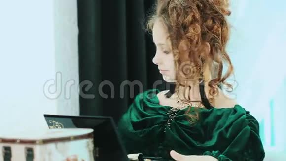 头发卷曲的小女孩坐在镜子前放戒指视频的预览图