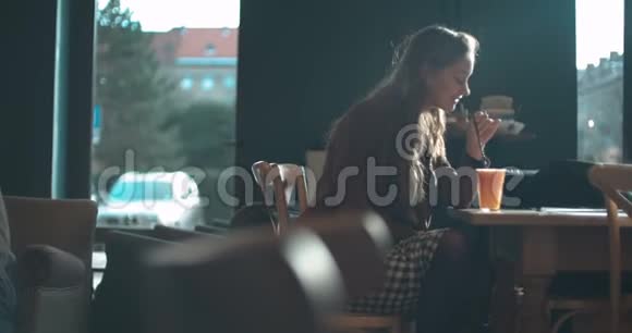 年轻漂亮的女人在橙汁餐厅放松视频的预览图