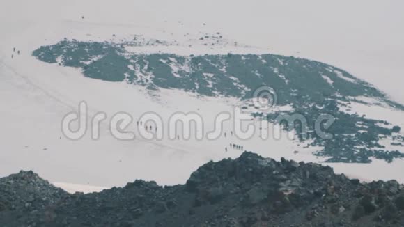 徒步行走在雪山坡上的行人视频的预览图