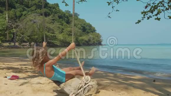 开心地笑着的女孩带着有趣的情绪在热带沙滩上摇摆视频的预览图