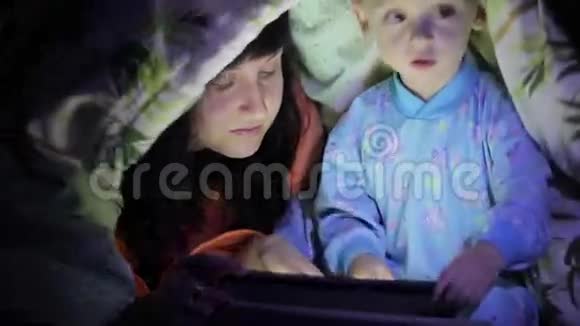 妈妈和她的宝贝在被子下面玩平板电脑视频的预览图