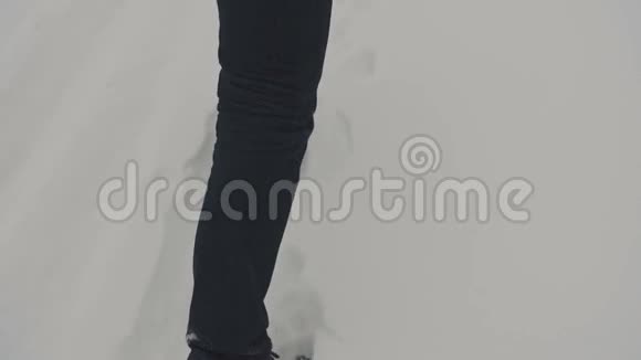 穿着黑色裤子和黑色鞋子走路雪视频的预览图