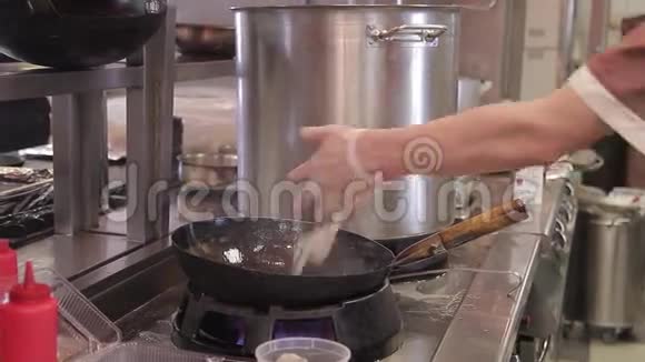 厨师在一个大火上用一个深油炸锅拌菜视频的预览图
