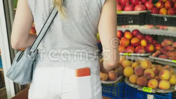 一个女人正在市场上选择蔬菜4k慢镜头视频的预览图