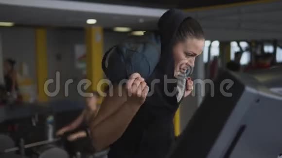 女人在跑步机上从事健身她肩上扛着一个包视频的预览图