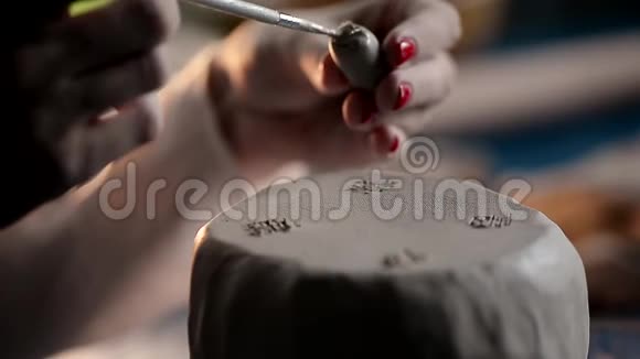 大师用刷子和水腿粘在一块粘土上创造过程视频的预览图
