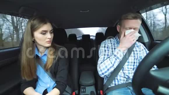 女孩给在车里打喷嚏的男孩餐巾视频的预览图