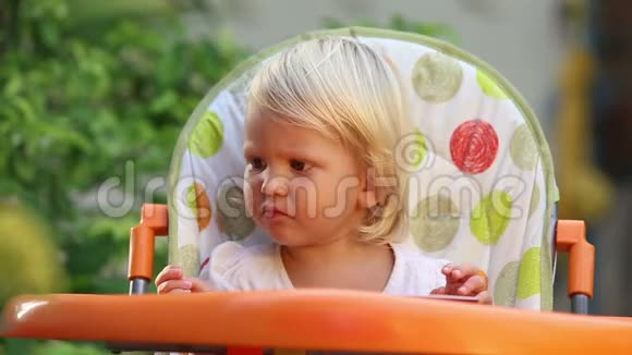 小女孩坐椅子和燕麦水果视频的预览图