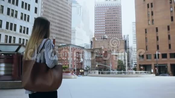 年轻漂亮的女人穿过美国纽约的金融区来到办公室慢动作视频的预览图