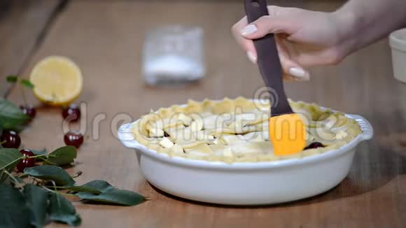 用新鲜樱桃派填充蛋糕的材料女人准备樱桃派把洗蛋器放在上面视频的预览图